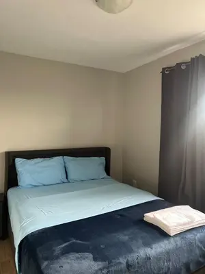 a bedroom with a bed with blue pillows at Modern Suite, 1 Guest Room in St. Catharines