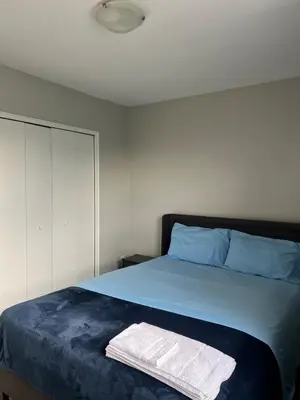 a bedroom with a bed with blue sheets and blue pillows at Modern Suite, 1 Guest Room in St. Catharines