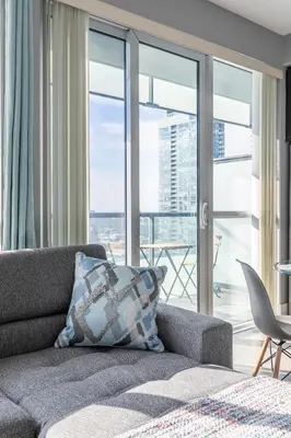 a living room with a couch and a large window at 1 Bedroom 26 Floor DT near CN Tower in Toronto