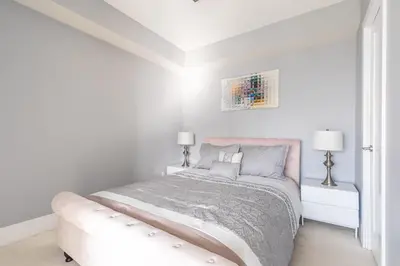 a white bedroom with a bed and a couch at 1 Bedroom 26 Floor DT near CN Tower in Toronto