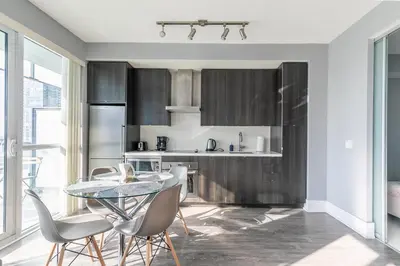 a kitchen with a glass table and chairs at 1 Bedroom 26 Floor DT near CN Tower in Toronto