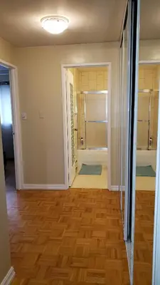 a room with a hallway with a shower and wooden floors at Bright 2 BR pet friendly, KING bed, WiFi,2 parking in Kitchener