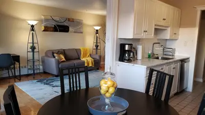 a kitchen and a table with a bowl of fruit on it at Bright 2 BR pet friendly, KING bed, WiFi,2 parking in Kitchener