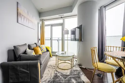 a living room with a couch and a table at Sunshiny 1 BD 61st Floor Outstanding View in Toronto