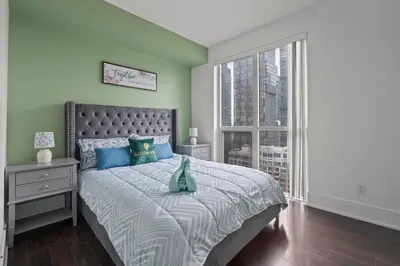 a bedroom with a bed and a large window at Elegant 1 Bedroom in Downtown Toronto in Toronto