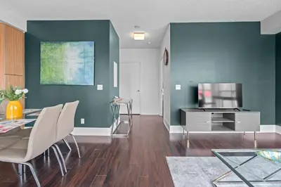 a living room with a dining table and a television at Elegant 1 Bedroom in Downtown Toronto in Toronto