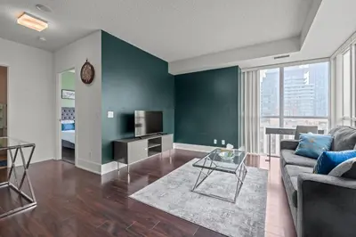 a living room with a couch and a tv at Elegant 1 Bedroom in Downtown Toronto in Toronto