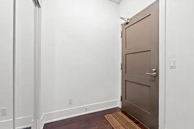 a door in a room with white walls and wood floors at Elegant 1 Bedroom in Downtown Toronto in Toronto