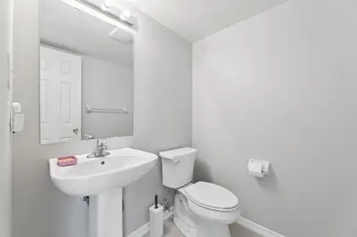 a white bathroom with a sink and a toilet at The Devineridge Executive House in Ajax
