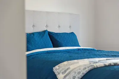 a blue bed with blue pillows in a bedroom at The Devineridge Executive House in Ajax
