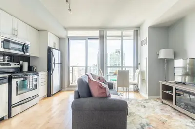 a living room with a couch and a kitchen at 1 Bedroom Condo Bremner Blvd Downtown Toronto in Toronto