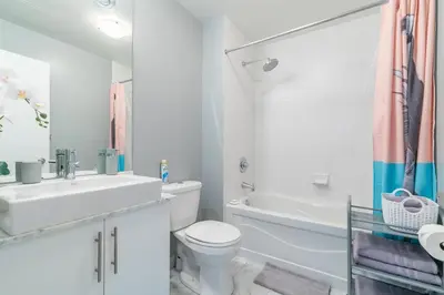 a white bathroom with a toilet and a sink at 1 Bedroom Condo Bremner Blvd Downtown Toronto in Toronto