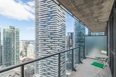 an apartment balcony with a view of a skyscraper at 1 Bedroom Condo Bremner Blvd Downtown Toronto in Toronto