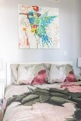 a painting of a bird hanging above a bed at 1 Bedroom Condo Bremner Blvd Downtown Toronto in Toronto
