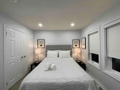 a white teddy bear laying on a bed in a bedroom at Elegant Oakville Town Residece in Oakville