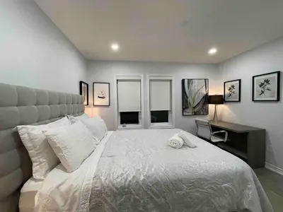 a bedroom with a large white bed and a desk at Elegant Oakville Town Residece in Oakville