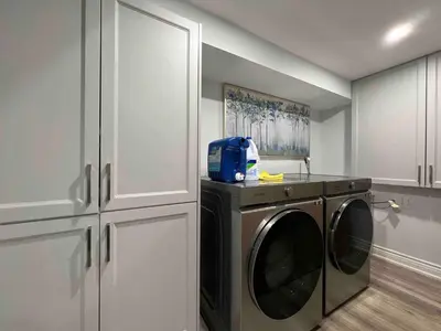 a laundry room with a washing machine and cabinets at Elegant Oakville Town Residece in Oakville