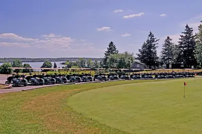 a long line of antique cars parked next to a field at Eganridge Resort, Golf Club & Spa in Bobcaygeon