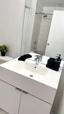 a bathroom with a white sink and a mirror at Downtown Toronto luxury condos in Toronto