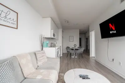 a living room with a white couch and a tv at Downtown Toronto luxury condos in Toronto