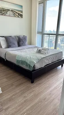a large bed in a bedroom with a large window at Downtown Toronto luxury condos in Toronto