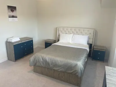 a bedroom with a bed and two night stands at New 3 Bedroom 2 Bathroom Home in West Niagara in Thorold