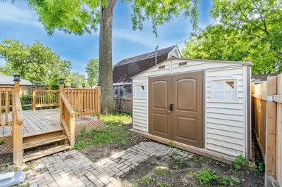 a small white shed next to a wooden fence at The Millertime Experience in Brantford