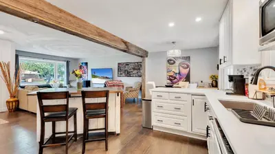 a kitchen with white cabinets and a table with chairs at R&R Heaven Music 4 the Soul See fall colors Hottub in Campbellford