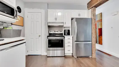 a kitchen with white cabinets and a stainless steel refrigerator at R&R Heaven Music 4 the Soul See fall colors Hottub in Campbellford