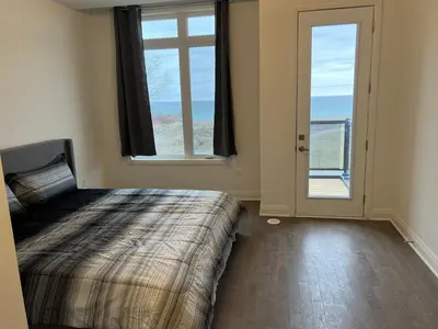 a bedroom with a bed and a large window at Bowmanville Room in Bowmanville