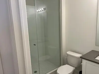 a bathroom with a glass shower with a toilet at Bowmanville Room in Bowmanville
