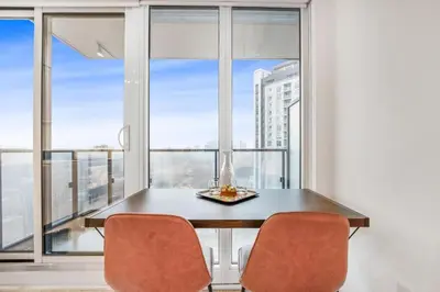 a dining room with a table and chairs and windows at 251 Jarvis st -Steps to Eaton Centre - Monthly Stays Only in Toronto