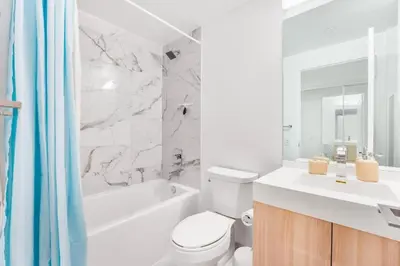 a white bathroom with a toilet and a tub and a sink at 251 Jarvis st -Steps to Eaton Centre - Monthly Stays Only in Toronto
