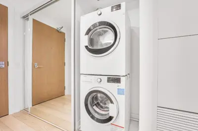 a washer and dryer in a room with a mirror at 251 Jarvis st -Steps to Eaton Centre - Monthly Stays Only in Toronto