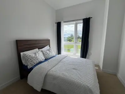 a bedroom with a bed and a large window at Stylish 2-Story Condo with Balcony in Kitchener