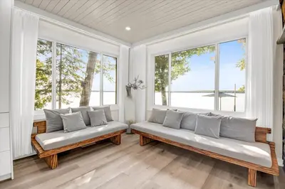 a living room with two couches in front of windows at Pet friendly- Crystal Water fishing Family Retreat in Havelock
