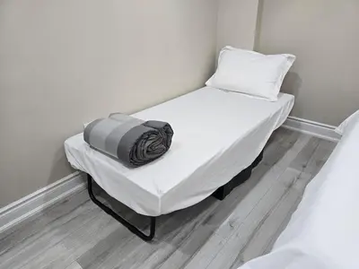 a small bed in a room with a pillow on it at 3 bdrm 3 bath bsmt Brampton Toronto, Sleeps 16 in Brampton