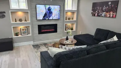a living room with a couch and a tv on a wall at 3 bdrm 3 bath bsmt Brampton Toronto, Sleeps 16 in Brampton