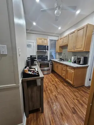 a kitchen with wooden cabinets and a counter top at King Comfort Retreat in Peterborough