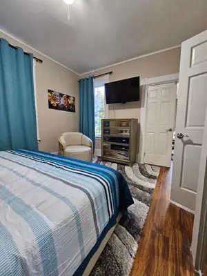 a bedroom with a bed and a flat screen tv at King Comfort Retreat in Peterborough