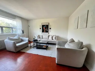 a living room with two couches and a table at Upper Beaches Apartment in Toronto