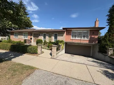 a brick house with a garage on a driveway at 9mins airport 1 min to shopping mall in Toronto