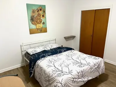 a bedroom with a bed and a painting on the wall at 9mins airport 1 min to shopping mall in Toronto