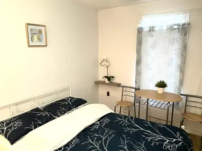 a bedroom with a bed and a table and a window at 9mins airport 1 min to shopping mall in Toronto