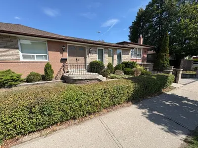 a brick house with a porch and a sidewalk at 9mins airport 1 min to shopping mall in Toronto