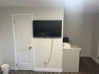 a flat screen tv on top of a white wall at Sunrise Motel in Owen Sound