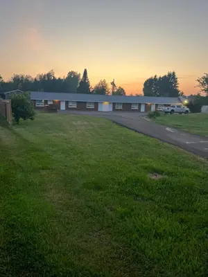 a building with a grass field in front of it at Sunrise Motel in Owen Sound