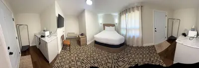 a hotel room with a bed and a bathroom at Sunrise Motel in Owen Sound