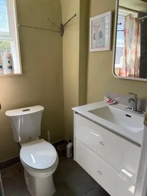 a bathroom with a toilet and a sink and a mirror at Tom home in Toronto