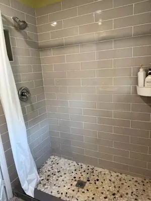 a bathroom with a shower with a tiled floor at Tom home in Toronto